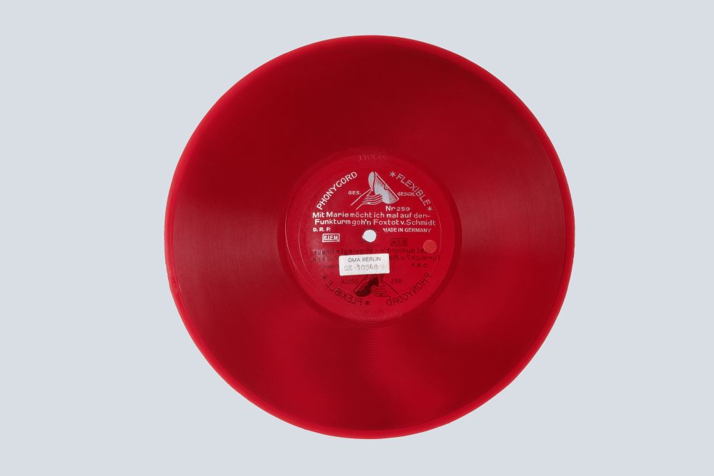 Eine rote Schallplatte aus halbtransparentem Kunststoff.