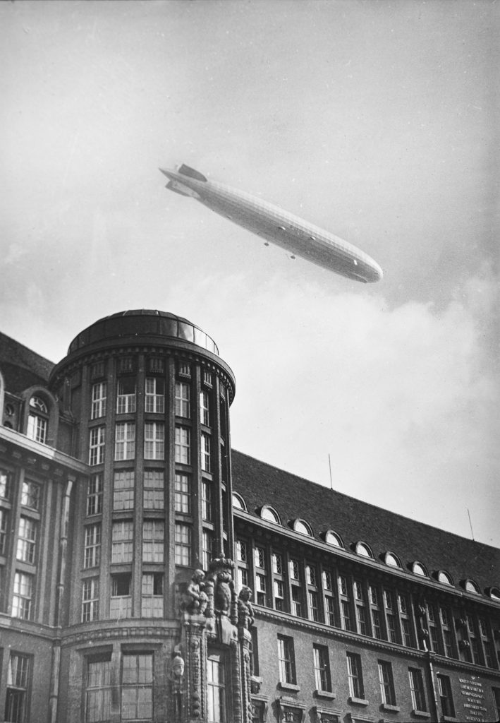 Hauptgebäude der Deutschen Bücherei, darüber am Himmel ein Zeppelin