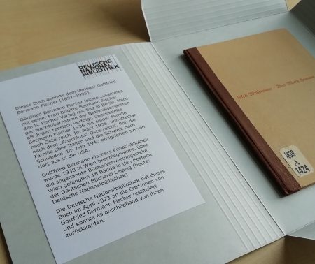 Aufgeschlagene Buchschachtel, in der das Buch "Über Moritz Heimann" von Jacob Wassermann liegt. Ein Exlibris auf der Innenseite der Buchschachtel informiert mit einem kurzen Text über die Provenienz des Buchs.