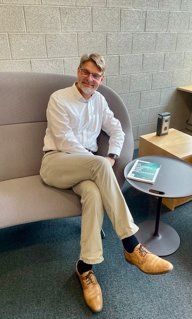 Generaldirektor Frank Scholze und sein Buch aus einem Sofa im Benutzungsbereich der DNB Frankfurt