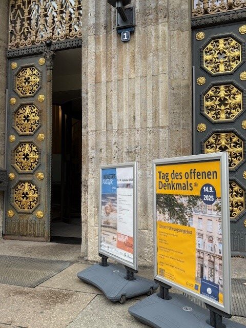Aufsteller mit Plakat vor dem offenen Haupteingang