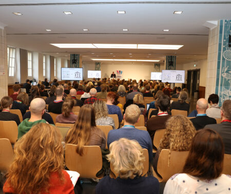 Ein großer Saal, in dem viele Menschen sitzen.