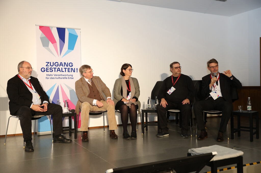 Fünf Personen sitzen auf einer Bühne und reden