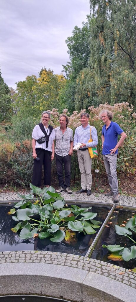 Vier Personen stehen vor hohen Pflanzen