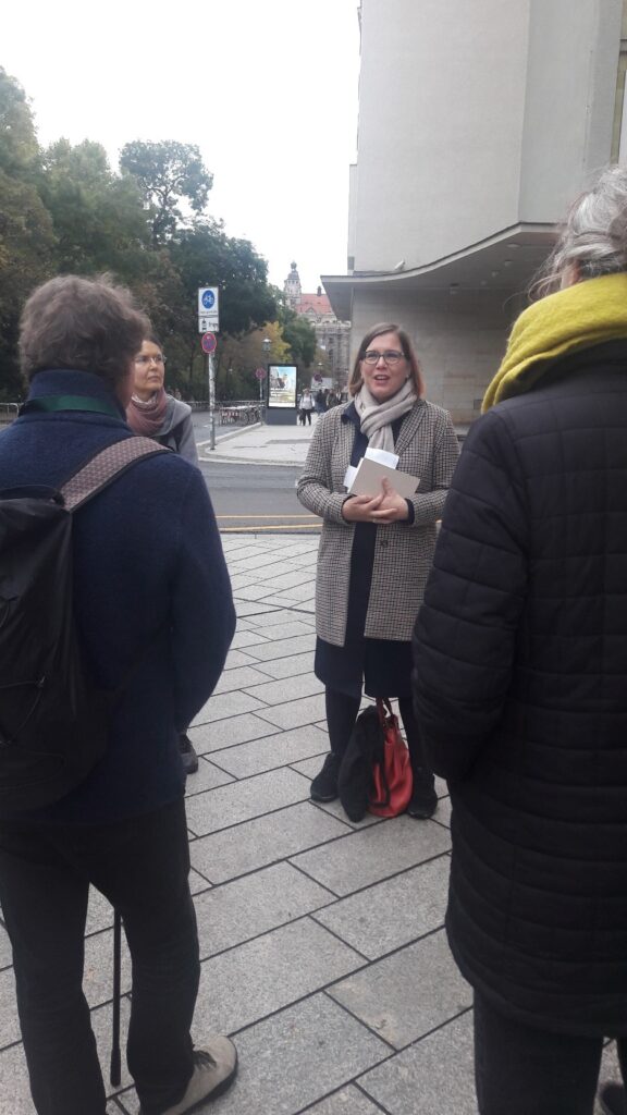 Zwei Personen schauen eine Frau an, die gerade spricht