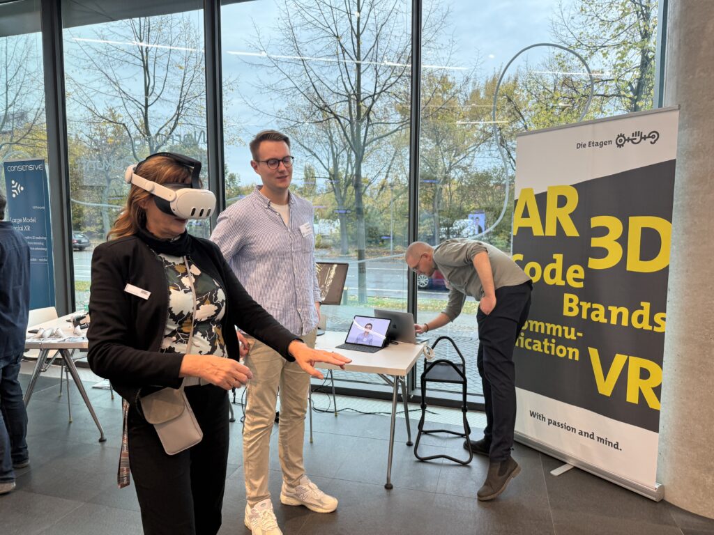 Frau mit VR-Brille steckt die Hand aus, um etwas virtuell zu bedienen