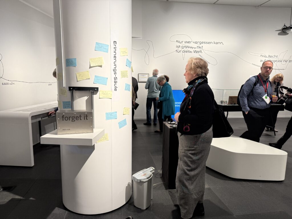 Eine Frau schaut sich die Klebezettel an einer weißen Säule an.