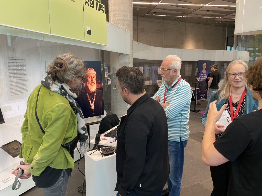 Mehrere Menschen schauen sich eine KI-Animation an und diskutieren miteinander.