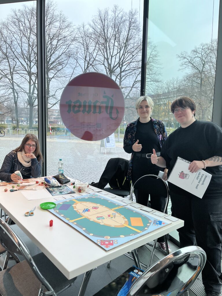 Drei Personen spielen ein Brettspiel