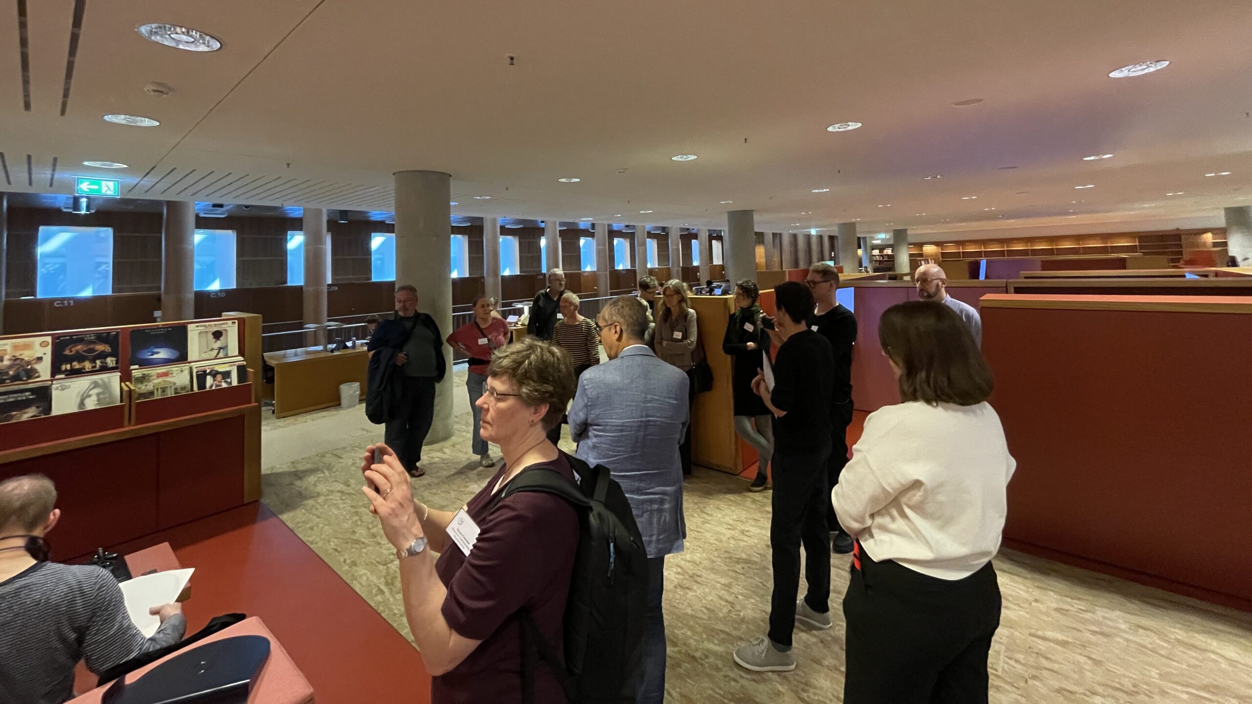 Eine Gruppe Menschen steht in einem Raum. Sie sieht sich dessen besondere Ausstattung an und macht Fotos.