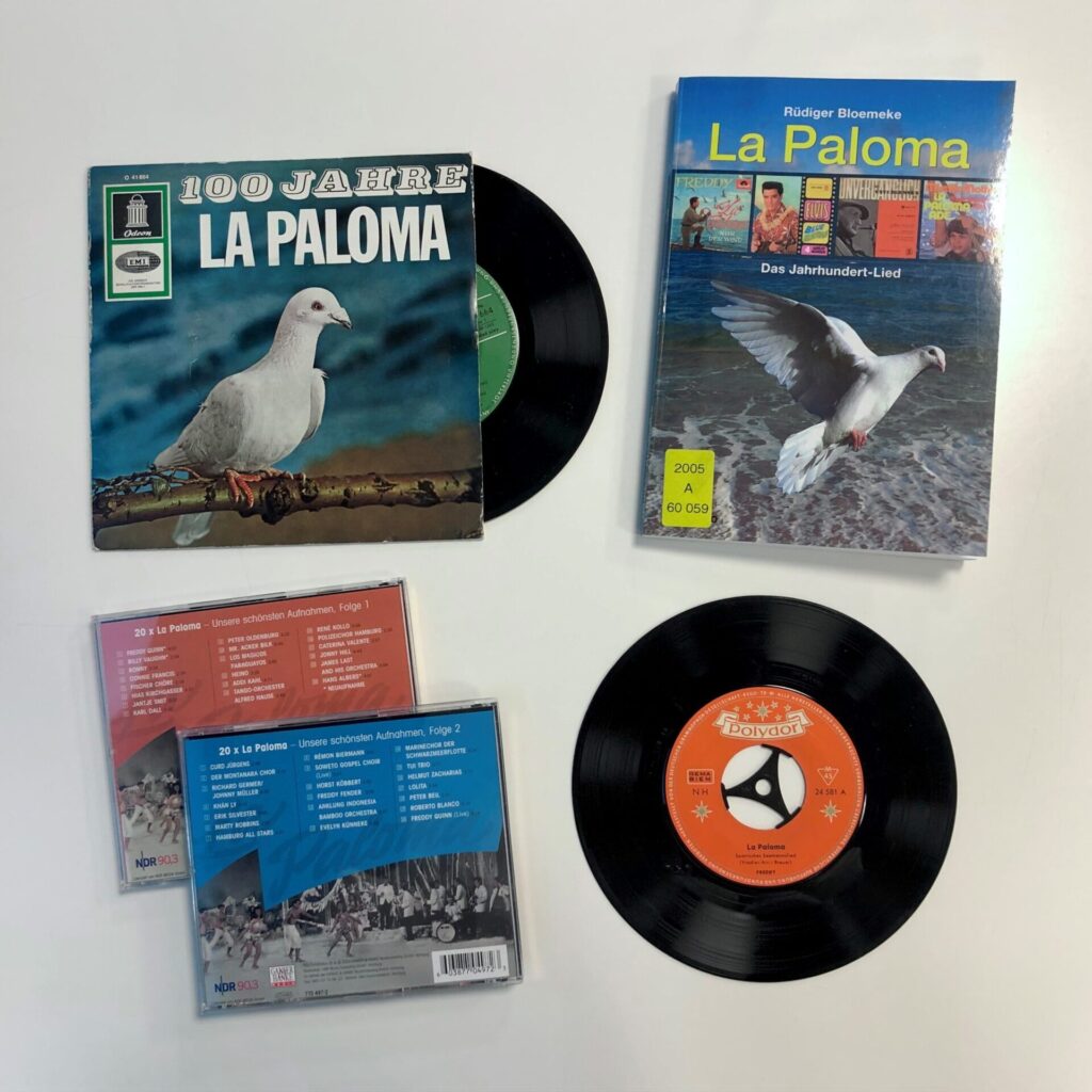 Verschiedene Tonträger aus dem Bestand des Deutschen Musikarchivs und ein Buch aus dem Bestand der Deutschen Nationalbibliothek zu La Paloma
