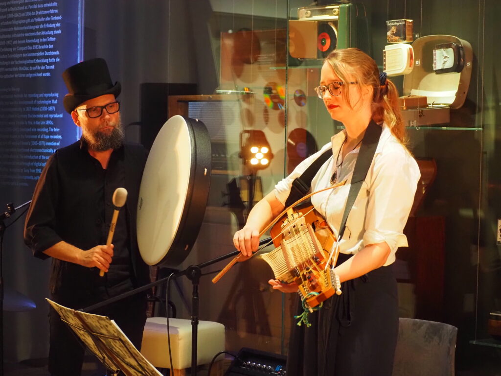Musikerin mit Nyckelharpa und Musiker mit Buffalo Drum