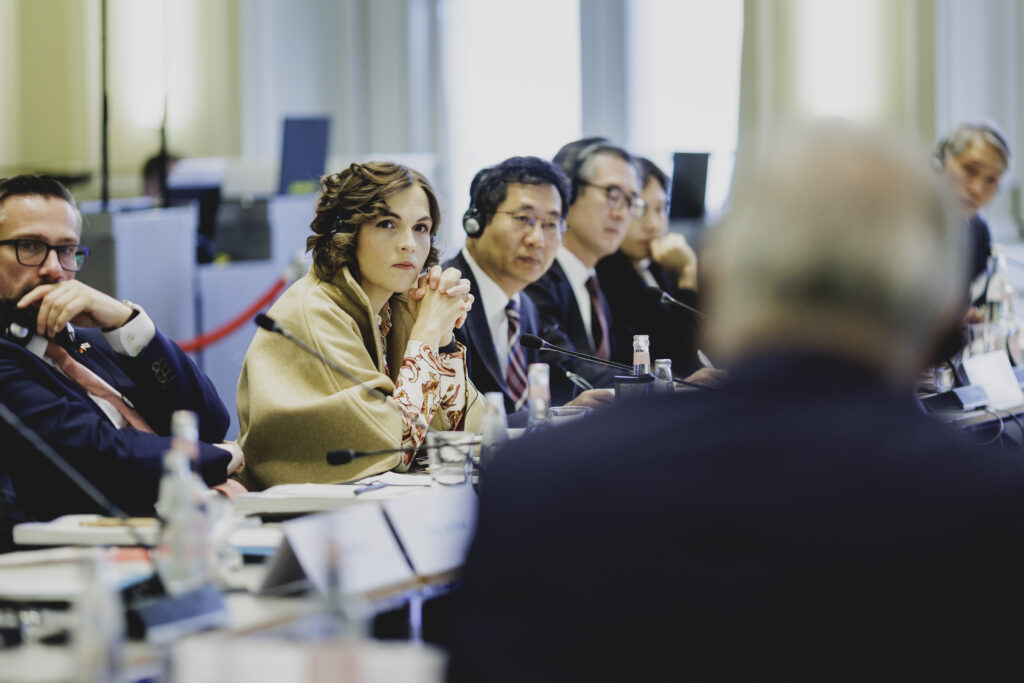 Konferenzteilnehmer hören einem Redner außerhalb des Bildes aufmerksam zu.