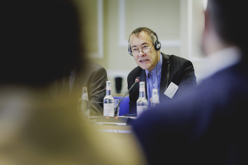Ein Mann mit Brille und Headset spricht auf der Konferenz.