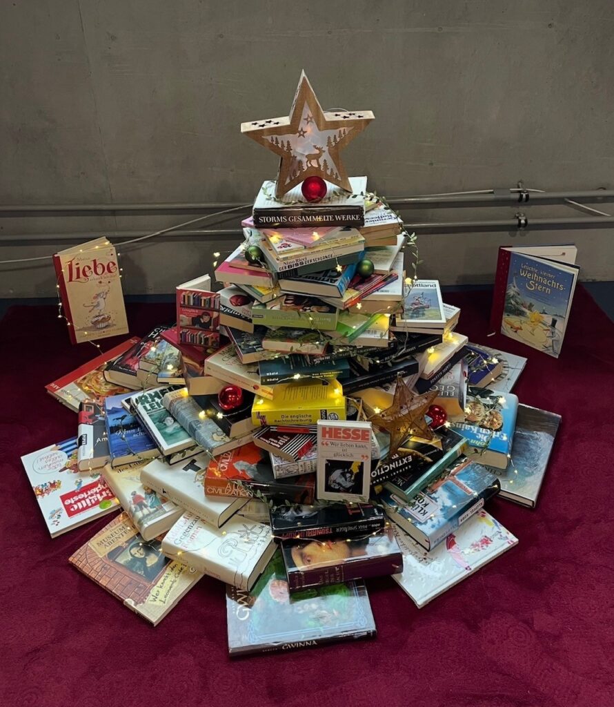 Ein Weihnachtsbaum aus Büchern mit Lichtern und Stern