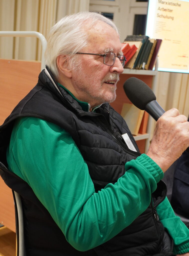 Ein Mann redet in ein Mikrofon.