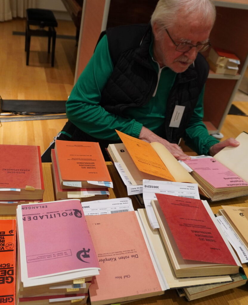 Ein Mann über einen Bücherstapel gebeugt