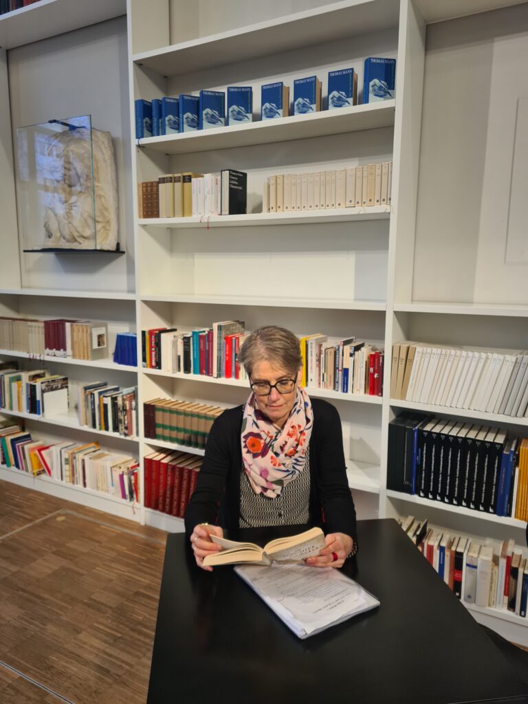 Die Autorin heidi Rehn vor einer Bücherwand in der Monacensia, München