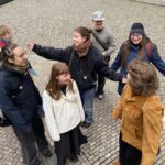 Sieben junge Menschen stehen zusammen und haben Spaß