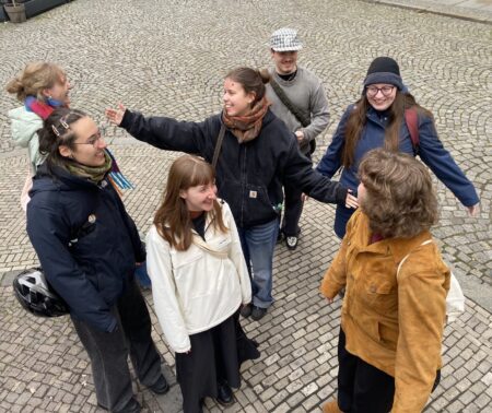 Sieben junge Menschen stehen zusammen und haben Spaß