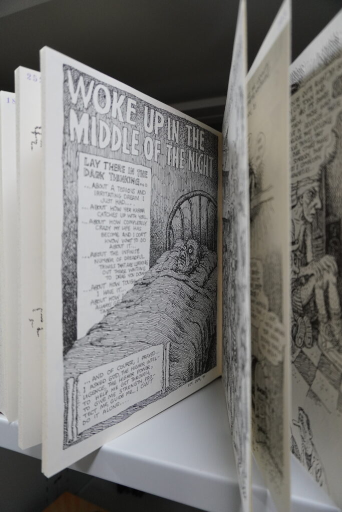 Aufgebläterter Comic im Magazin. Eine Seite zeigt einen im Bett liegenden Mann, darüber steht "Woke up in the middle of the Night".