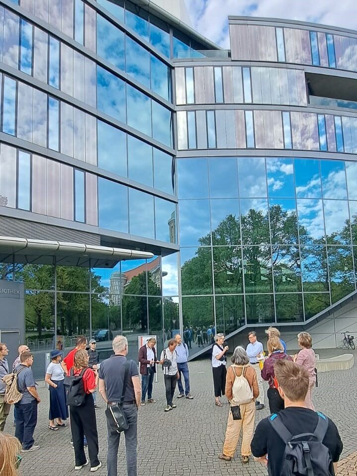 Menschen stehen vor einer Glasfassade