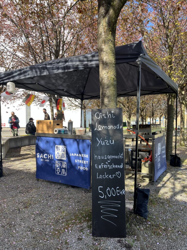 Stand mit japanischem Street Food unter Kirschbäumen