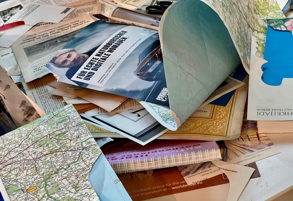 Materialien für eine Collage. Karten, alte Zeitungen und Ausschnitte aus Magazinen