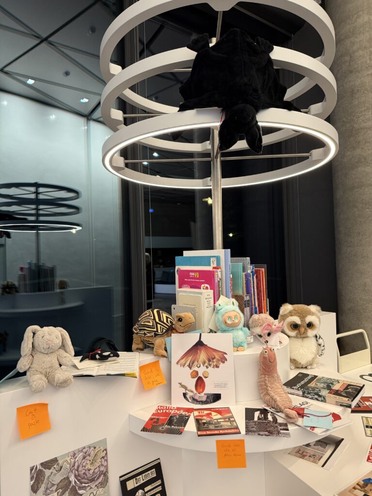 In der Leseecke haben es sich mehrere Kuscheltiere gemütlich gemacht. An der Lampe hängt eine Plüsch-Fledermaus.