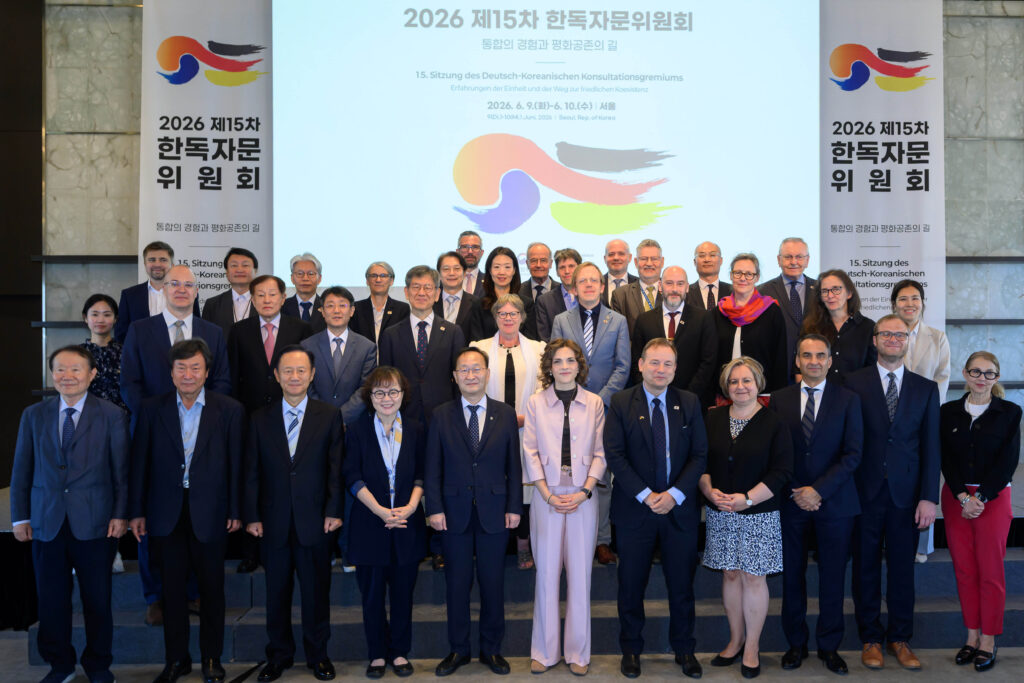 Gruppenbild aller Teilnehmenden vor Bannern mit dem Logo und Titel der deutsch-koranischen Regierungskonsultation.