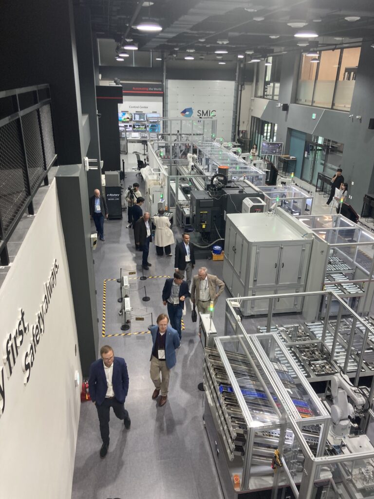 Menschen besichtigen eine moderne Produktionsstraße in einer Fabrik.
