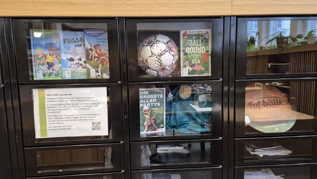 Medienboxen von Nahem. Darin befindet sich ein Fußball und mehrere Bücher über Fußball.