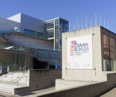 An einer Mauer der Konzerthalle Thessaloniki prangt ein Banner, das auf den IAML-Kongress hinweist.