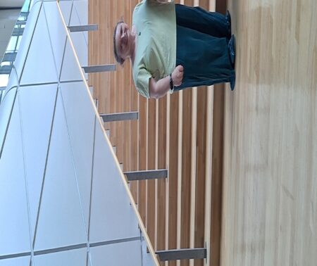 3 Personen stehen vor einer großen Treppe