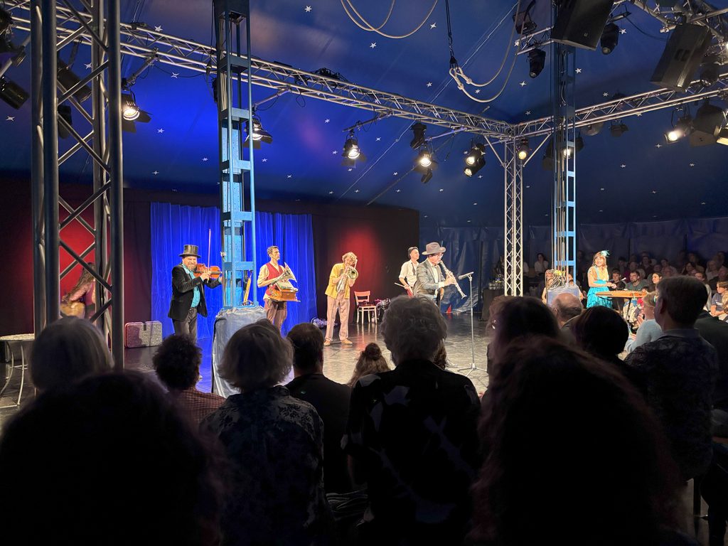 Die Musiker*innen der Klezmer-Band Dobranotch bei ihrem Auftritt in einem Zirkuszelt.