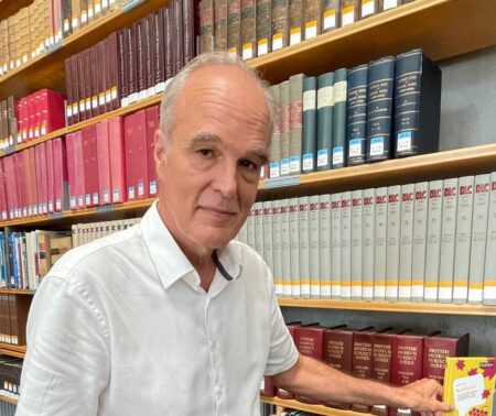 Der Autor Frank Winter mit seinem Buch Badisch vor einer Bücherwand