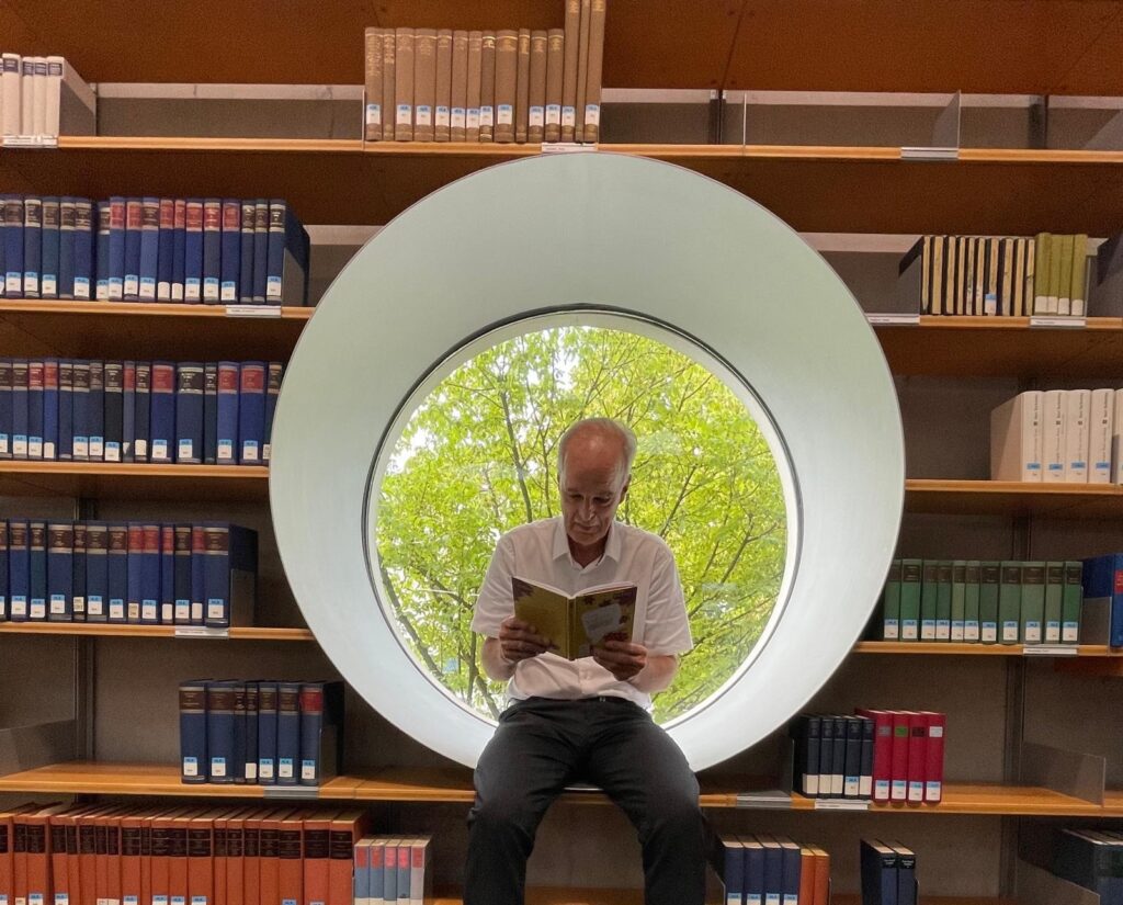 Der Autor Frank Winter mit seinem Buch Badisch im Fenster sitzend
