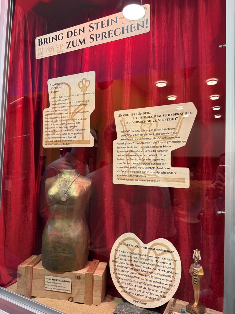 Vitrine mit Ausstellungstexten sowie einer Büste mit Anhänger
