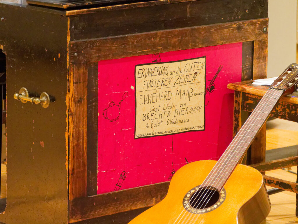 Nahaufnahme eines alten Harmoniums mit selbstgezeichneten Postern.